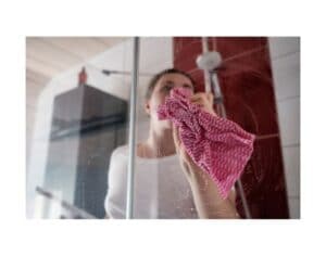 Immagine di donna che pulisce box doccia